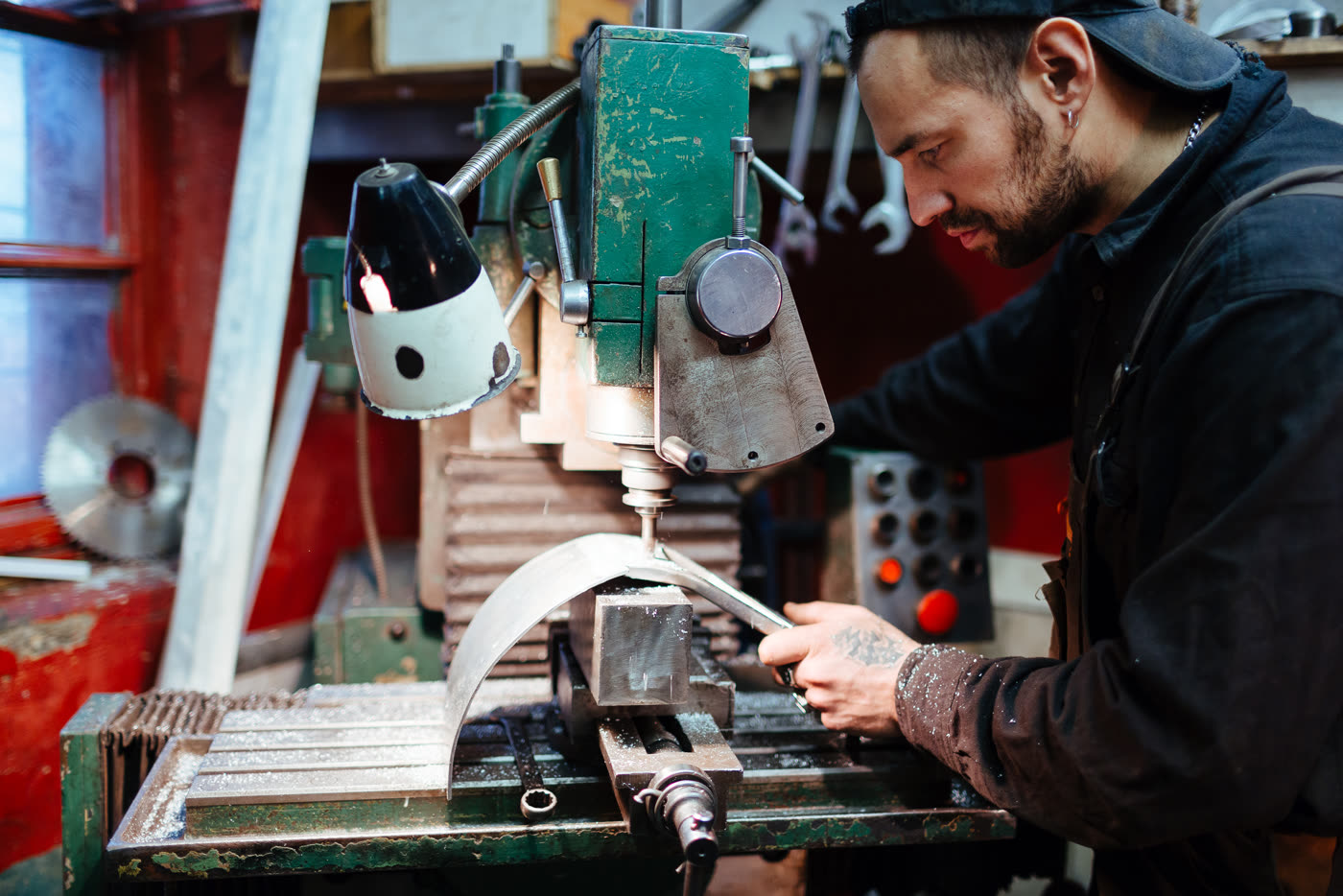 A machinist working at a drill press
